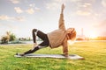 Picture of mature woman making yoga asanas (side plank pose) outdoors on sunrise Royalty Free Stock Photo