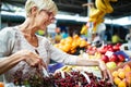 Picture of mature woman at marketplace buying vegetables Royalty Free Stock Photo