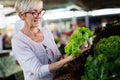 Picture of mature woman at marketplace buying vegetables Royalty Free Stock Photo