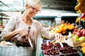 Picture of mature woman at marketplace buying vegetables Royalty Free Stock Photo