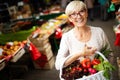 Picture of mature woman at marketplace buying vegetables Royalty Free Stock Photo