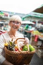 Picture of mature woman at marketplace buying vegetables Royalty Free Stock Photo