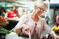 Picture of mature woman at marketplace buying vegetables Royalty Free Stock Photo