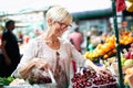 Picture of mature woman at marketplace buying vegetables Royalty Free Stock Photo