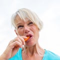 Mature woman bites in a carrot Royalty Free Stock Photo