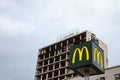Mc Donald`s logo with its iconic M in front of a half destroyed building in downtown Belgrade