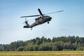 Military helicopter flying in the sky with forest at the background