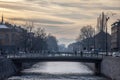 Pedestrians passing by a bridge on the Miljacka river in Sarajevo at Sunset Royalty Free Stock Photo