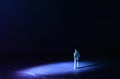 A picture of a miniature man stands in the spotlight looking forward.Concept of facing the unknown, taking a decision and finding