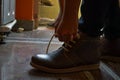 Model tiding laces of his brown color boots