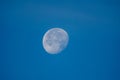 A picture of moon in the blue sky.