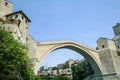 Old Bridge of Mostar during a sunny afternoon, with the old city visible in the background.