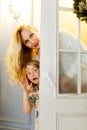 Picture of mother and daughter peeping out from behind door Royalty Free Stock Photo