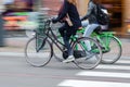 young women riding bicycle on a city street Royalty Free Stock Photo