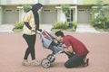 Muslim family kissing their baby in the stroller Royalty Free Stock Photo