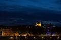 Panorama of Colline de Fourviere Hill at night seen from the riverban of the Rhone river. Notre Dame de Fourviere, the main basili