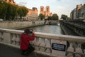 Tourist taking a picture of Notre Dame de Paris Cathedral from a bridge over the Seine River on Ile de la Cite Island Royalty Free Stock Photo