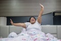 Obese woman stretching hands after wake up