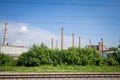 Panorama of an abandoned industrial factory complex with its typical tall red brick chimneys while cables and railway tracks Royalty Free Stock Photo