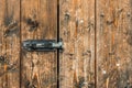 Picture of old brown colored wooden door locked with a padlock