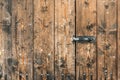 Picture of old brown colored wooden door locked with a padlock