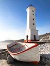 Picture of old lighthouse and wooden boat on the seashore of Magadan, Russia Royalty Free Stock Photo