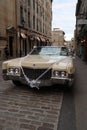 This is a picture of an old school Cadillac. The sign above shows Venice.