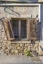 Picture of an old window with a damaged shutter in an old stone house Royalty Free Stock Photo