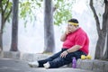 Overweight man resting after exercise in the park