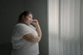 Pensive obese woman looking out the window Royalty Free Stock Photo