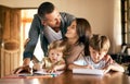 The picture of perfect parenting. a young family of four drawing and getting creative together at home. Royalty Free Stock Photo