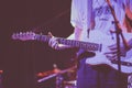 Picture of a person playing a white electric guitar during a concert covered in blue lights Royalty Free Stock Photo