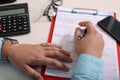 Picture of phone and hand with pen on the form. Photo of calculator, glasses and clipboard on the table Royalty Free Stock Photo