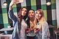 Picture presenting happy group of friends with red wine taking selfie