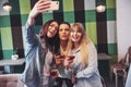 Picture presenting happy group of friends with red wine taking selfie