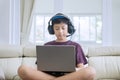 Preteen boy using a laptop and headphones Royalty Free Stock Photo