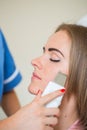 Picture of pretty beautician doing microdermabrasion procedure f