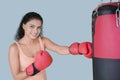 Pretty girl punching a boxing bag on studio Royalty Free Stock Photo
