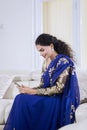 Pretty Indian woman using a mobile phone at home Royalty Free Stock Photo