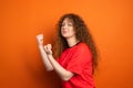 Picture of pretty redhead female fan in sport football uniform keeping fists for her football team victory, human Royalty Free Stock Photo