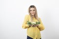 Picture of a pretty woman model standing and holding cauliflower in hand