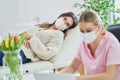 Professional psychiatrist consulting her patient and making notes both in masks