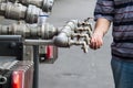 Water tap made of several pipes, with hands trying to hold water to save it & drink it. This faucet distributes clean drink water Royalty Free Stock Photo