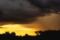 A picture of a rain cloud with a lot of noise, a photograph of a falling rainstorm, a large storm cloud over a shadowy forest.