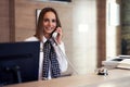 Receptionist answering phone at hotel front desk Royalty Free Stock Photo