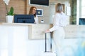 Receptionist and businesswoman at hotel front desk