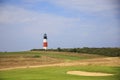 Red and white lighthouse near a golf course