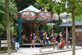 Picture of a retro carousel installed in the famous Botanical Garden of Paris, families are having good time.