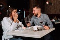 Young happy couple romantic date drink glass of red wine at restaurant, celebrating valentine day Royalty Free Stock Photo