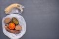 Rotten vegetable and fruits in cellophhane bags on the grey background Royalty Free Stock Photo